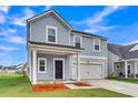 Charming two-story home featuring a covered front porch and an attached two car garage at 141 Woodland Oak Way, Summerville, SC 29485