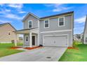 Charming two-story home featuring a covered front porch and an attached two car garage at 141 Woodland Oak Way, Summerville, SC 29485