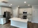 Modern kitchen features white cabinets, stainless steel appliances, and an island with a sink at 1817 Edgewood Dr, Charleston, SC 29407
