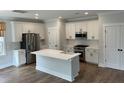 Modern kitchen features white cabinets, stainless steel appliances, and an island with a sink at 1817 Edgewood Dr, Charleston, SC 29407