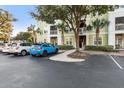 Bright exterior of a multi-story condo building with palm trees, mature trees and blue car in the parking area at 1821 Chatelain Way # 1821, Mount Pleasant, SC 29464