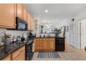 A view of the kitchen showing wooden cabinets, black appliances, and an open view to the living room at 2244 Ashley Crossing Dr # 426, Charleston, SC 29414