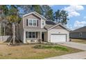 Charming two-story home with a two car garage, manicured lawn, and solar panels on the roof at 324 Spruce Ivy St, Moncks Corner, SC 29461