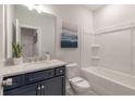 Well-lit bathroom with a navy vanity, tub, and a modern gray countertop sink at 416 Katies Scenic Ct, Charleston, SC 29492
