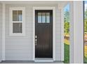Elegant black front door with glass panes, framed by white trim, and a small window at 417 Grove End Rd, Moncks Corner, SC 29461