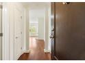 Inviting entryway with dark wood door, view into the home, white columns, and gleaming hardwood floors at 498 Albemarle Rd # 306, Charleston, SC 29407