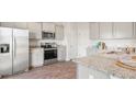 Well-lit kitchen showcasing stainless steel appliances, granite countertops, and wood-look flooring at 7014 Deanston Dr, Ravenel, SC 29470
