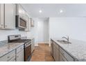 Modern kitchen showcasing stainless steel appliances, gray cabinetry, and a granite countertop with a sink at 7018 Deanston Dr, Ravenel, SC 29470