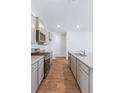 Modern kitchen showcasing stainless steel appliances, gray cabinetry, and a granite countertop with a sink at 7018 Deanston Dr, Ravenel, SC 29470