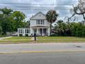 Charming two-story home with a cozy front porch, lush landscaping, and mature palm trees at 715 Hampton St, Walterboro, SC 29488
