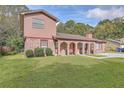 Charming two-story home with an arched brick porch, benches, and a front lawn at 7791 Peppercorn Ln, North Charleston, SC 29420