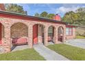 Inviting brick porch with arched entryways and cozy red benches at 7791 Peppercorn Ln, North Charleston, SC 29420