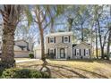 Charming two-story home at 7932 with a well-manicured front yard, complemented by a lovely palm tree at 7932 Riverbirch Ln, North Charleston, SC 29418