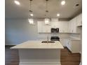 Bright kitchen with white cabinets, a large center island, stainless steel appliances, and modern pendant lighting at 818 Descartes St, Summerville, SC 29486