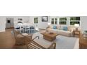 Bright living room with hardwood floors, a comfortable sofa, and large windows showcasing the natural light at 1037 Swamp Rose Run, Summerville, SC 29485