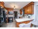 Well-lit kitchen with warm wood cabinetry, contrasting black appliances, and a cozy breakfast bar at 112 Ravenswood Ct, Summerville, SC 29485