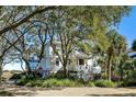 Charming home with mature trees providing shade and privacy, complemented by a welcoming entryway and staircase at 1136 Ocean Forest Ln, Seabrook Island, SC 29455