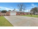 Spacious brick home with a long driveway leading to a garage, surrounded by a green lawn at 117 Swan Dr, Summerville, SC 29485