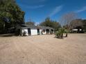Wide shot of a white brick ranch-style home surrounded by a large yard and mature trees at 1344 Pickett St, Charleston, SC 29412