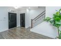 Welcoming foyer with hardwood floors, staircase, and stylish black doors at 1399 Tollison Path, Mount Pleasant, SC 29466
