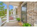 Charming covered front porch with white railings and brick accents, perfect for enjoying the outdoors at 1399 Tollison Path, Mount Pleasant, SC 29466