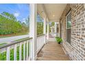 Inviting covered front porch with views of the lush landscape and tree-lined street at 1399 Tollison Path, Mount Pleasant, SC 29466