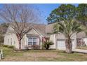 Attractive home with a well-kept lawn, mature trees, and an attached garage on a sunny day at 1465 Water Edge Dr, Charleston, SC 29492