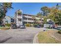 Exterior shot of the complex featuring a parking lot, lush landscaping, multiple levels, and convenient access points at 1530 Fort Johnson Rd # 3C, Charleston, SC 29412