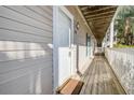 Hallway with a white door and brown door mat on a deck showcasing outdoor lights, outdoor furniture, and palm trees at 1530 Fort Johnson Rd # 3C, Charleston, SC 29412