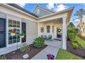 Inviting front porch with cozy seating, decorative wreath, and well-maintained landscaping at 157 Sea Lavender Ln, Summerville, SC 29486