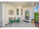 Charming front porch featuring a seating area, decorative wall art, and a festive wreath on the front door at 157 Sea Lavender Ln, Summerville, SC 29486