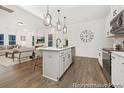 Open concept kitchen featuring stainless appliances, white cabinets, an island with bar seating that flows into the living room at 169 Surf Bird St # 514P, Summerville, SC 29486