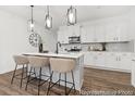 Stylish kitchen with white cabinets, stainless steel appliances, a center island with bar seating, and contemporary pendant lighting at 169 Surf Bird St # 514P, Summerville, SC 29486