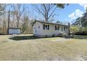 Quaint single-story home with black shutters and a utility shed in the backyard at 1879 Richmond St, Charleston, SC 29407