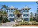 Charming two-story exterior featuring blue siding, white trim, a double garage, and well-manicured landscaping at 1899 N James Gregarie Rd, Mount Pleasant, SC 29466