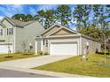 Inviting single-story home with an attached garage, a well-maintained lawn and traditional architectural style at 212 Sweet Cherry Ln, Summerville, SC 29486