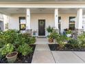Inviting front porch with cozy seating, plants and decorative accents at 217 Woodland Oak Way, Summerville, SC 29485