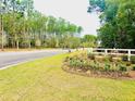 Well-manicured Hillcrest community entrance with landscaping and fencing near the street at 2278 Macallan Blvd, Ravenel, SC 29470