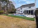 Backyard oasis with a sparkling pool, poolside lounge chairs, an outdoor table, and a manicured lawn at 2900 Colonnade Dr, Mount Pleasant, SC 29466