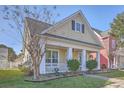 Charming two-story home featuring a cozy front porch with white columns and meticulously maintained landscaping at 303 Crossandra Ave, Summerville, SC 29483