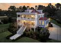 Stunning exterior of a multi-level home featuring wraparound porches and manicured landscaping at 3232 Pignatelli Cres, Mount Pleasant, SC 29466