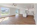 Bright living room with a ceiling fan, wood floors, large windows, and a view of the backyard at 359 Blue Oak Dr, Moncks Corner, SC 29461