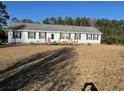 Charming single-story home featuring black shutters and a welcoming front porch with a ramp at 60 Caboose Ct, Cottageville, SC 29435