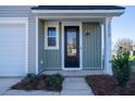 Inviting front door of a modern home featuring vertical siding, painted address numbers, and manicured landscaping at 6273 Ballpark Rd Rd, Hollywood, SC 29449