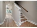 Open staircase design with wood-look flooring, neutral walls, and a simple wood railing in the foyer at 6273 Ballpark Rd Rd, Hollywood, SC 29449
