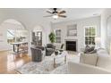 Bright living room with a fireplace, ceiling fan, plush seating, and elegant arched doorways at 644 Stoneboro Ct, Charleston, SC 29412
