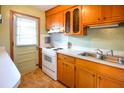Functional kitchen features bright countertops, a stainless steel sink, and wood cabinets at 7 Doughty St # C, Charleston, SC 29403