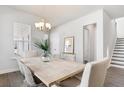 Bright dining area featuring a light-colored dining table, elegant chandelier, and windows overlooking the outdoors at 796 Clay Field Trl, Summerville, SC 29485