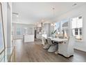 Bright, open-concept dining area featuring hardwood floors, large windows, and a view of the kitchen at 796 Clay Field Trl, Summerville, SC 29485