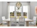Bright dining room featuring an elegant chandelier, large windows, and a stylish table setting at 800 Clay Field Trl, Summerville, SC 29485